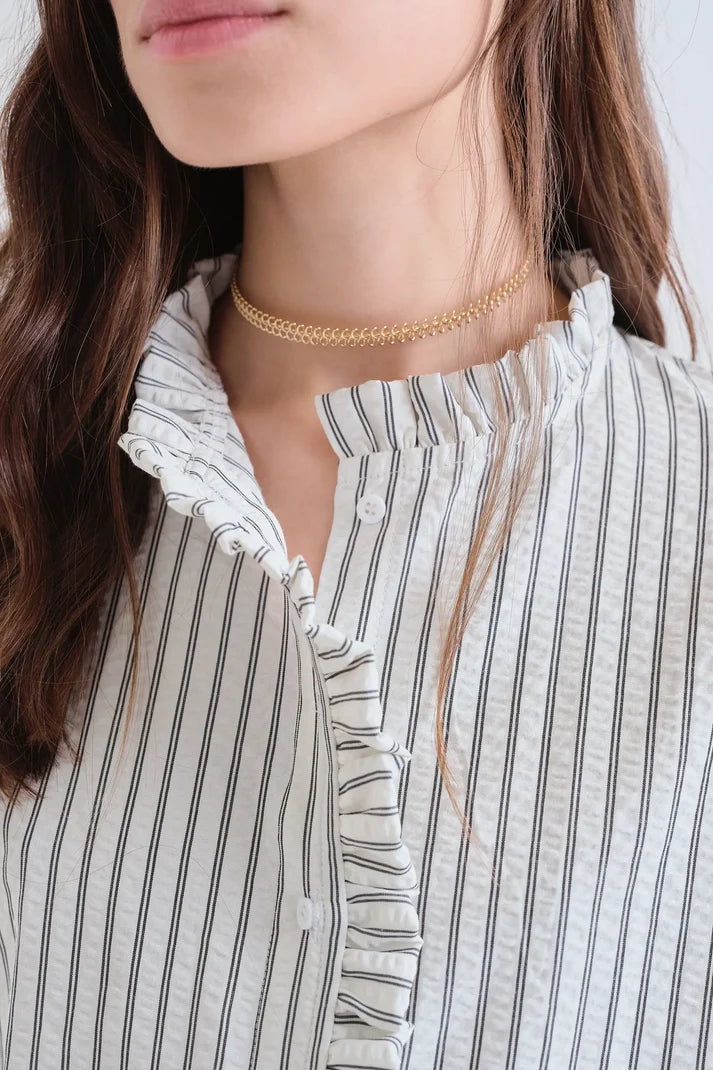 Camicia nera a righe con dettaglio di volant