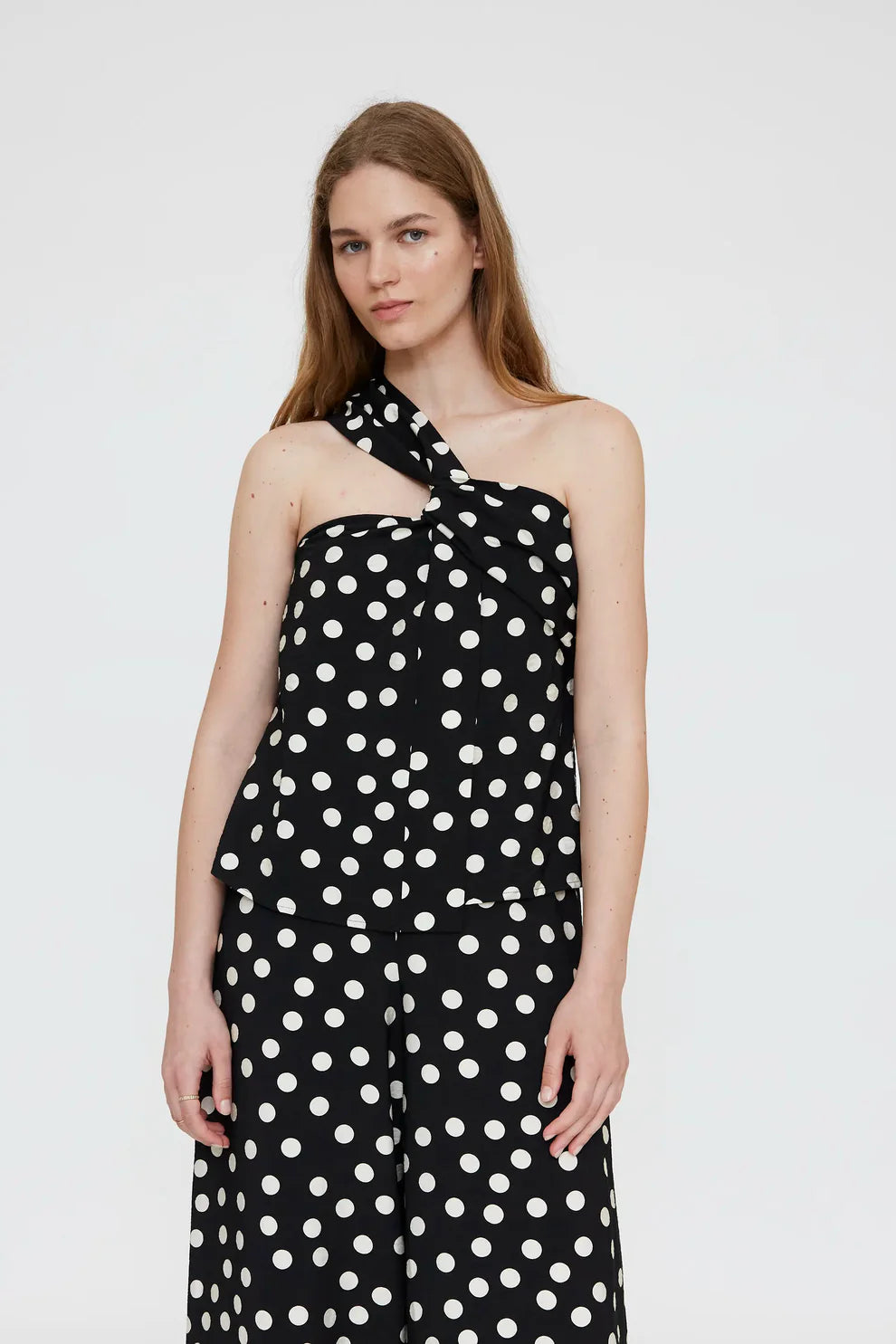 Top asimmetrico con stampa a pois bianco e nero