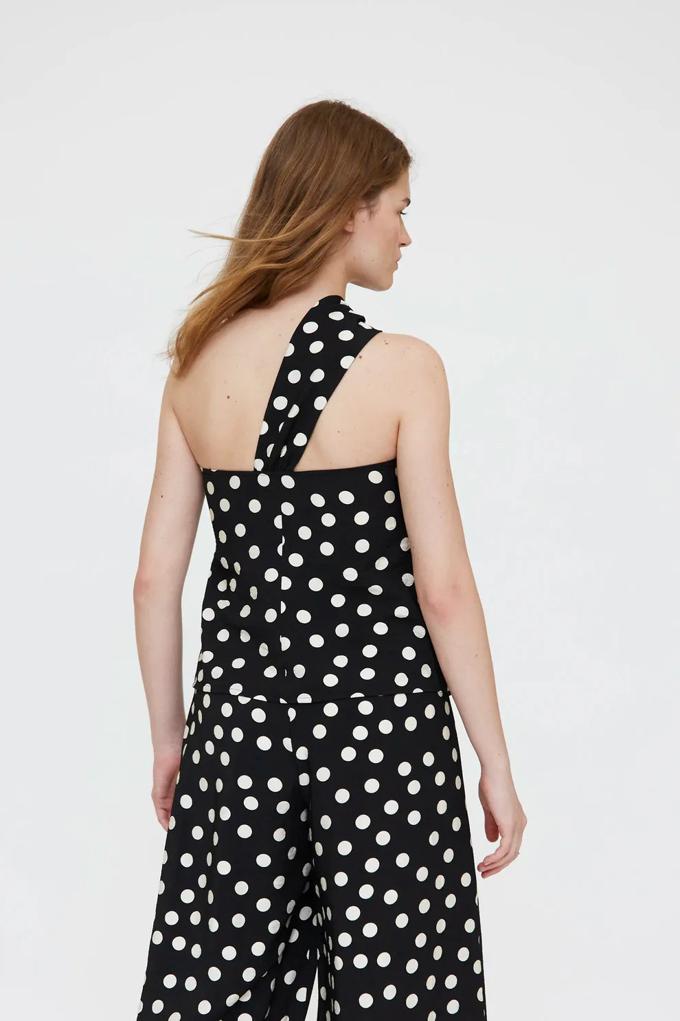Top asimmetrico con stampa a pois bianco e nero